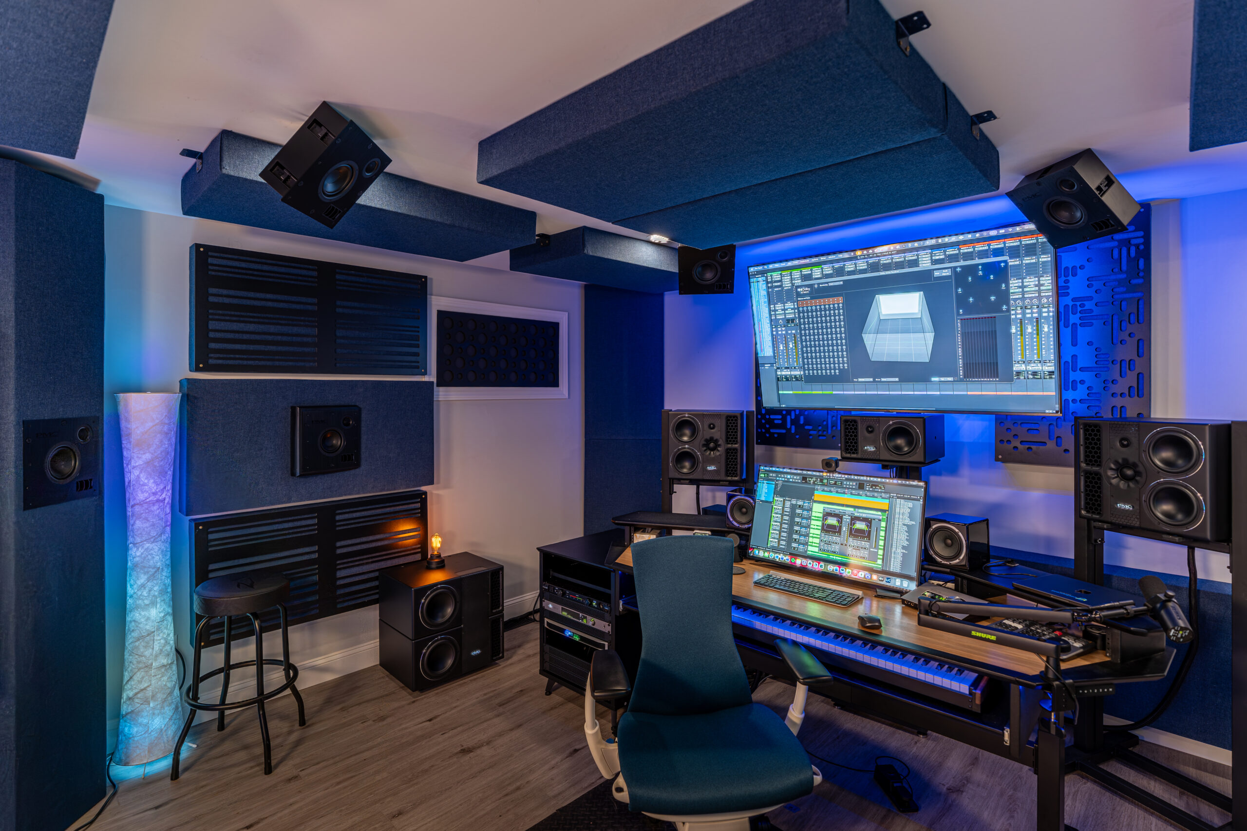 IndigoCorvid Atmos Studio control room with PMC monitors, audio interface, mixing desk, and acoustic treatment