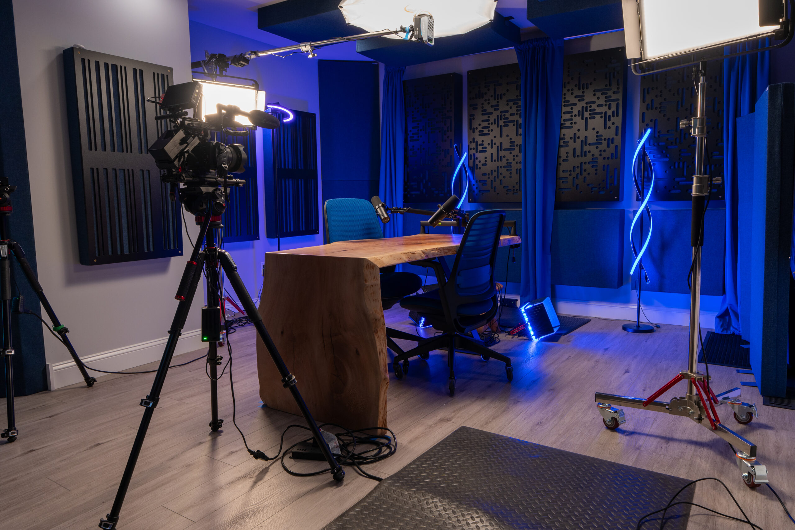 IndigoCorvid video production set with cinema camera, lighting, and microphone in a podcast/interview configuration